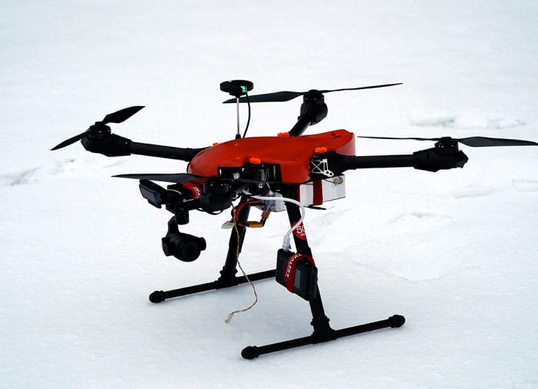 Punainen drone lumisessa maassa.