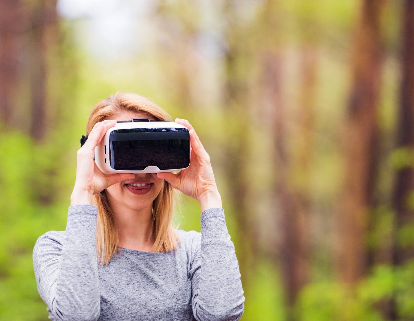 Naishenkilö katsoo metsää virtuaalilasien läpi.
