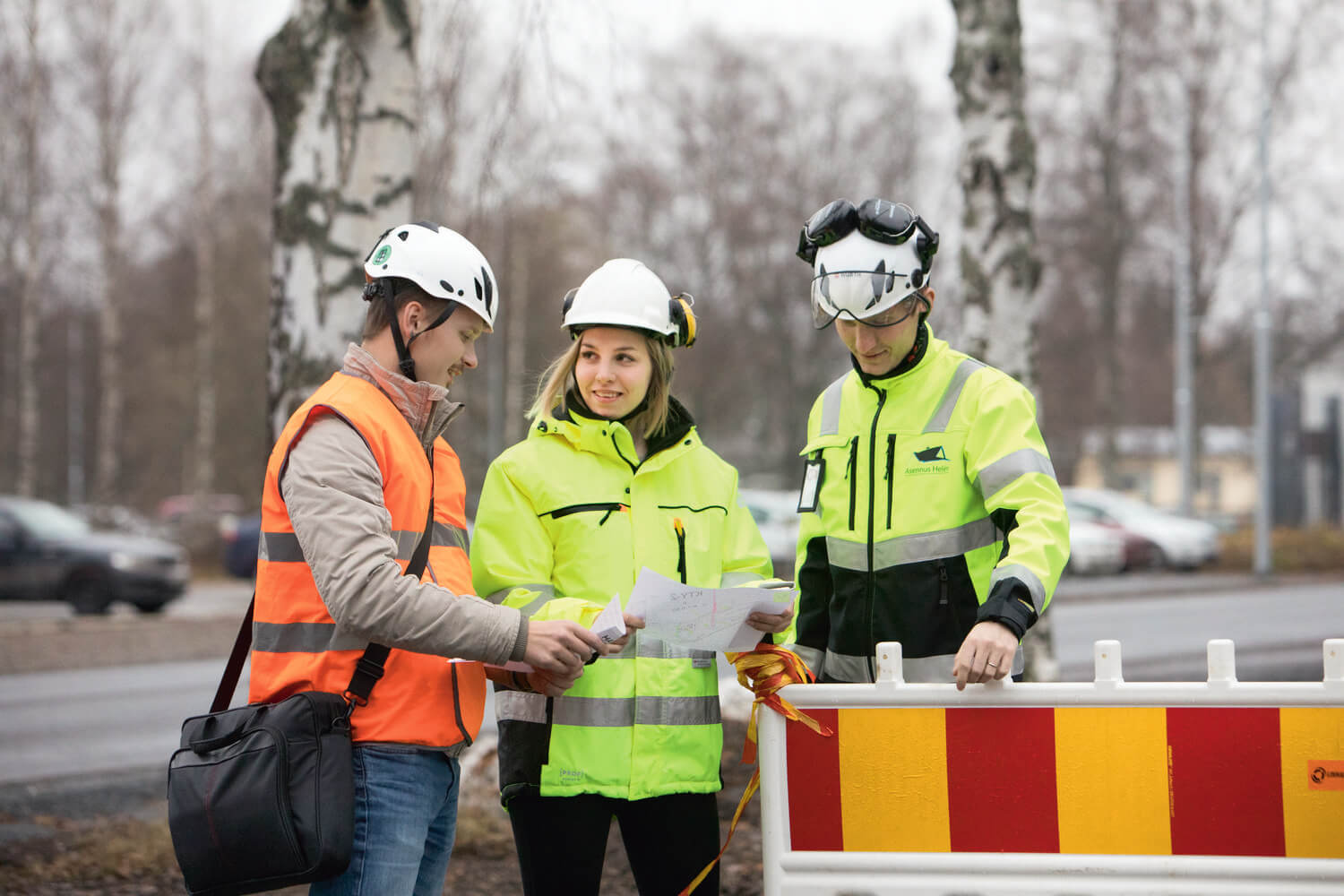 Kuvassa kolme työntekijää, joilla heijastavat työvaatteet päällä.