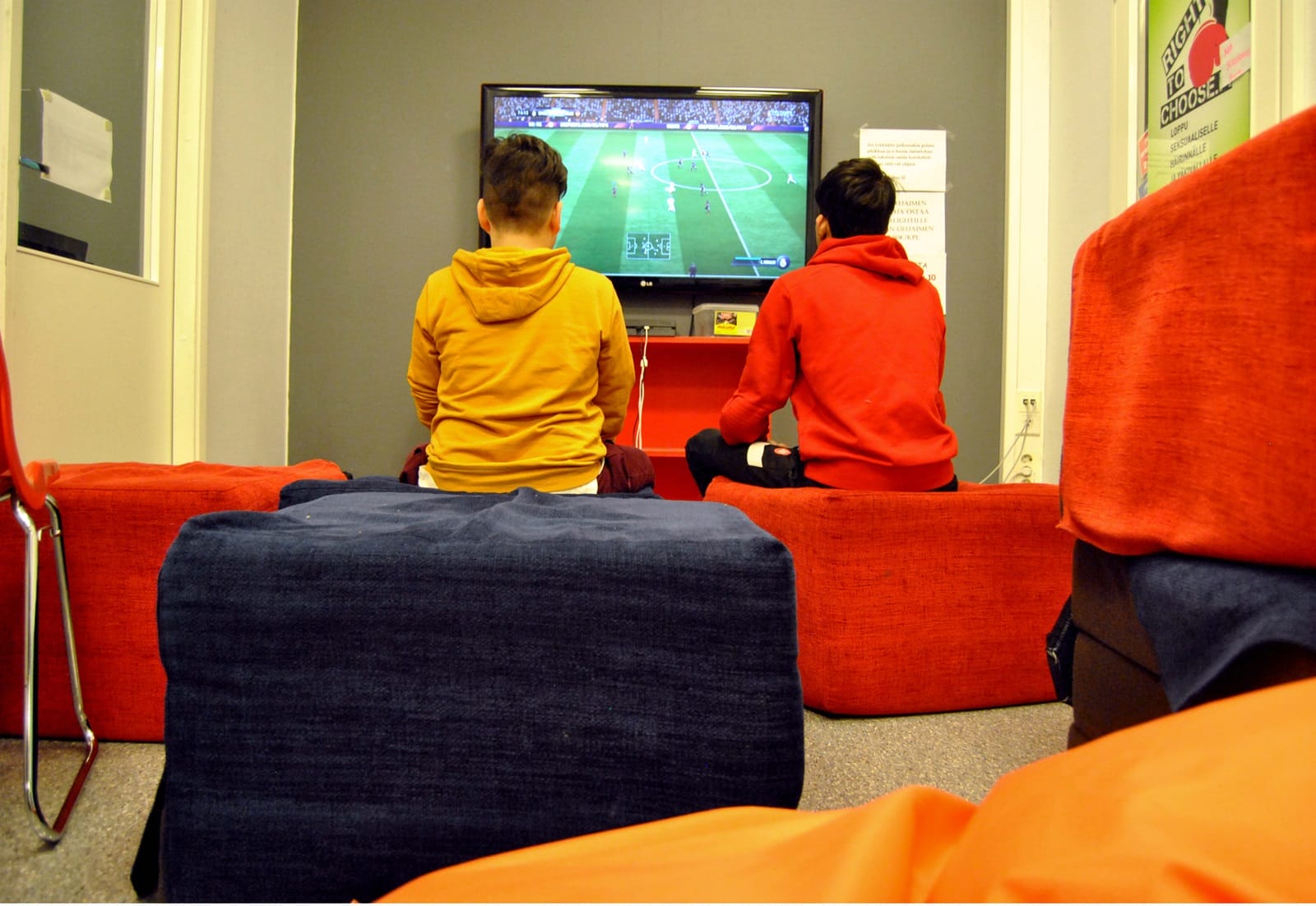 Photo. Two young persons playing with game console.