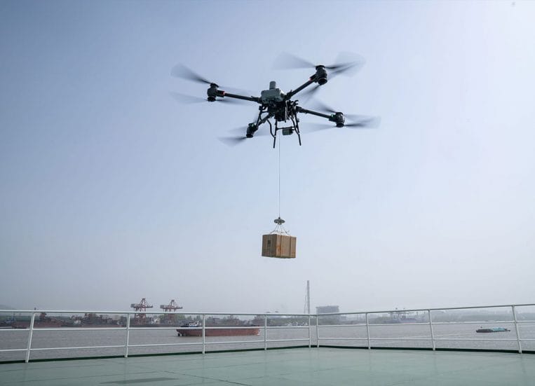 Drone kuljettaa rahtilaatikkoa ilmassa.