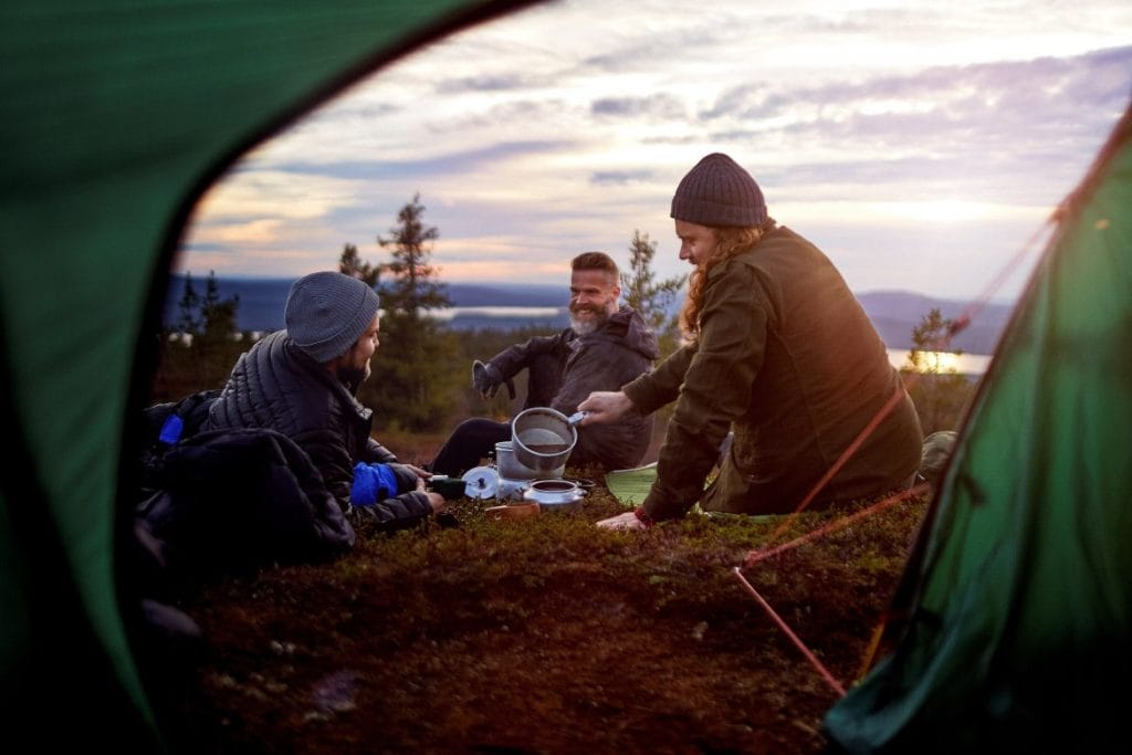 Kolme ihmistä telttaretkellä.
