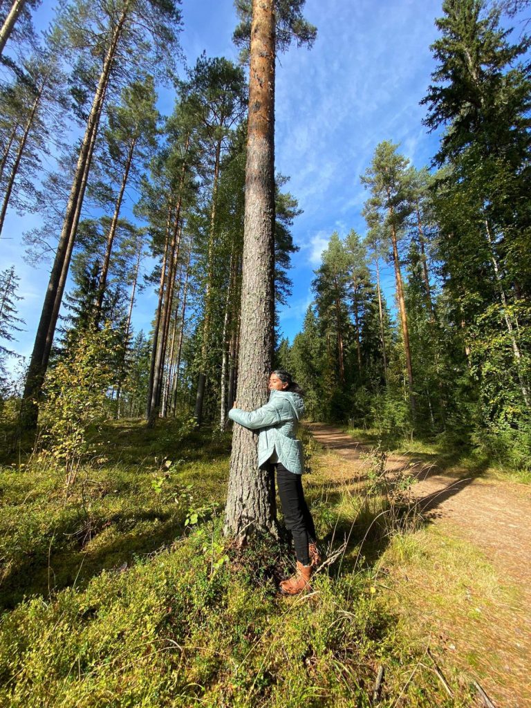 Nainen halaa puuta.