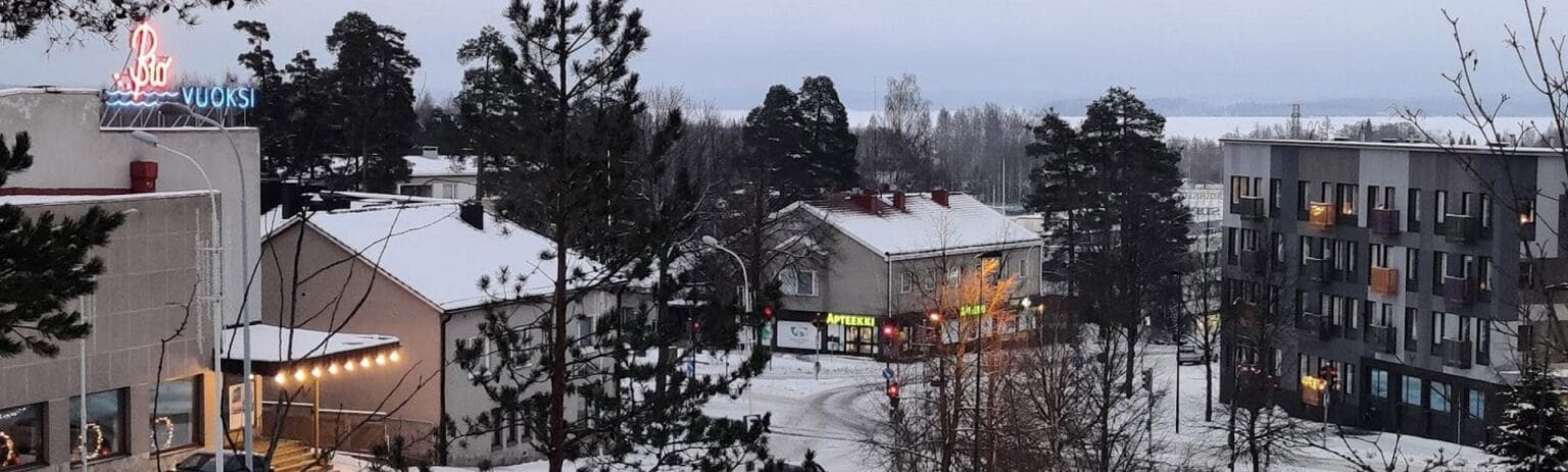 Valokuva. Ilmasta otettu kuva talvisesta taajamasta. Näkyvissä muun muassa apteekki.